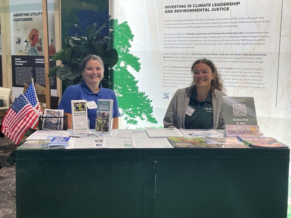 Two DAR employees at a booth handing out informational flyers.