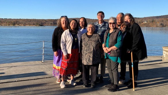 A group of people standing in front of the Hudson River.