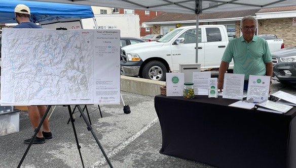 A man stands behind a table of information.