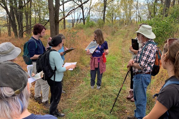 A group of people stand in a forest.