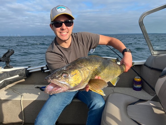 Angler on a boat holding a walleye