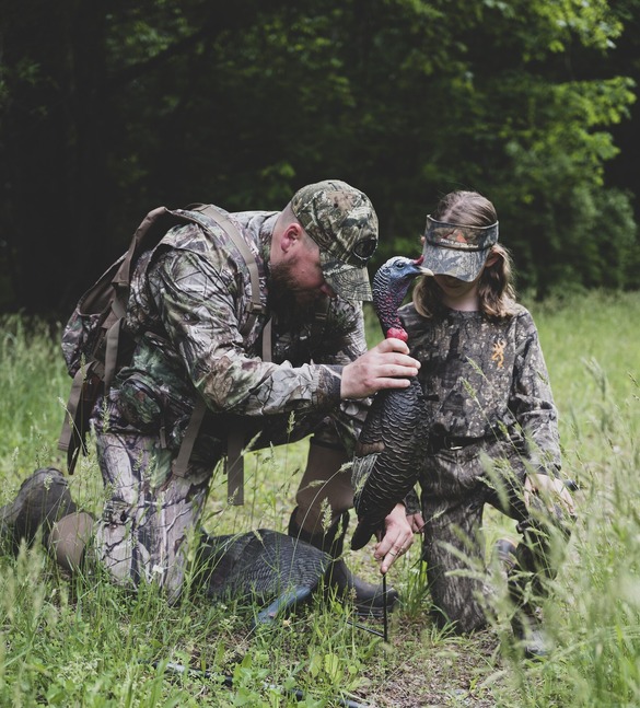 Two hunters setting up a turkey decoy
