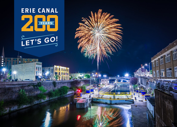 The “Erie Canal: 200 Years” emblem appears in the left top corner of a photo of fireworks exploding over a lock on the Erie Canal at night. 