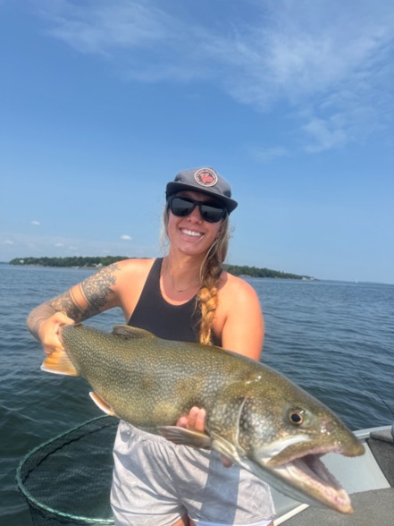 Person holding a Lake Trout on a boat on Lake Champlain