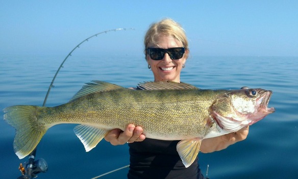 Angler holding up a walleye on a boat on Lake Erie
