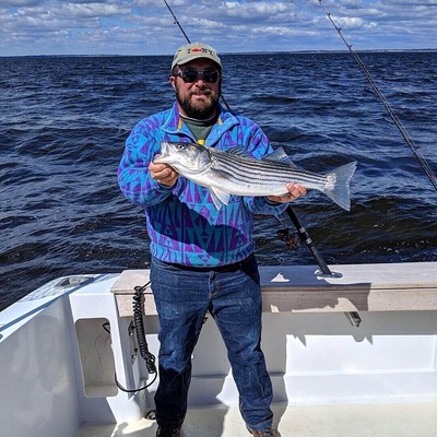 Fisherman holding a striped bass