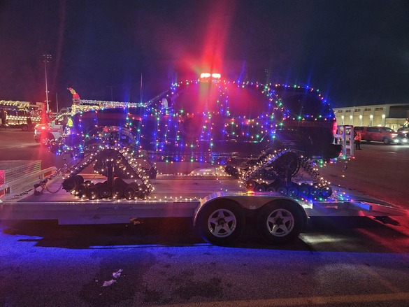 Truck covered in christmas lights on trailer at night