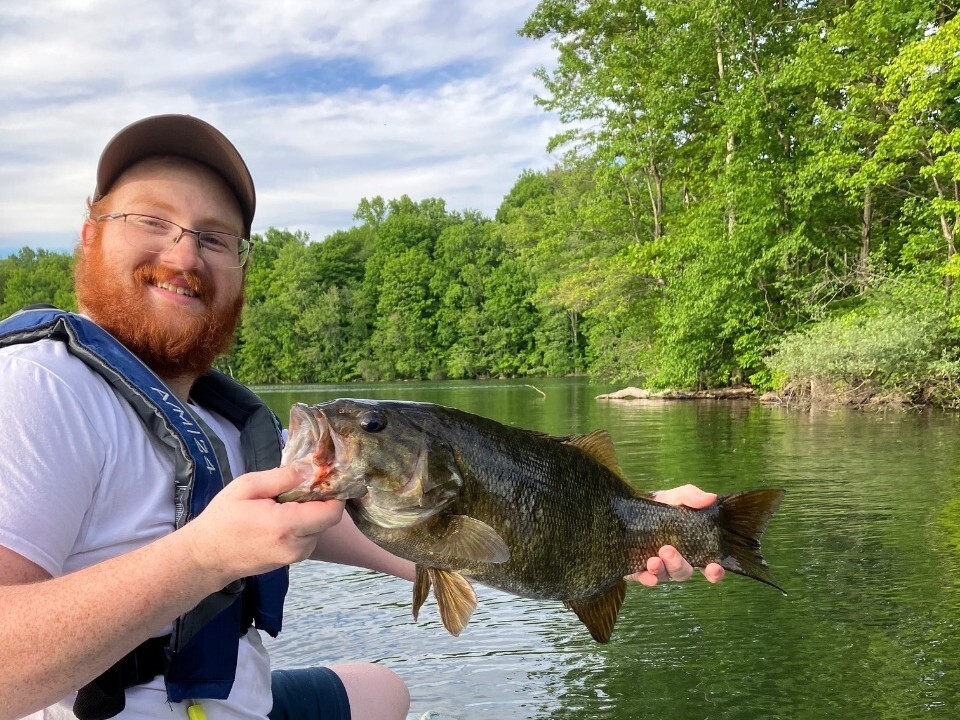 Angler holding up a largemouth bass on the water