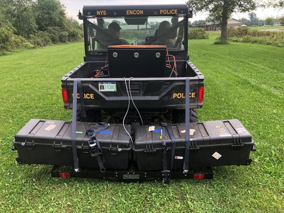 UTV with large black boxes strapped to the back