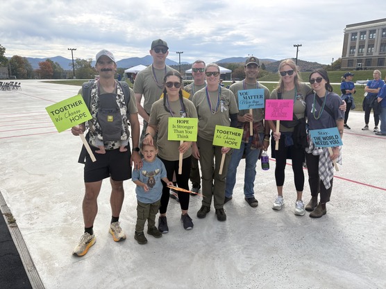People stand with signs for a group photo during Suicide Prevention Walk