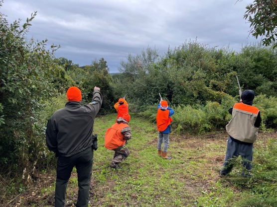 ECOs and youth hunters in hunting gear in a field