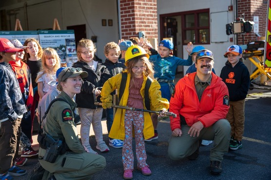 Rangers and a child in Ranger gear pose for a photo during event