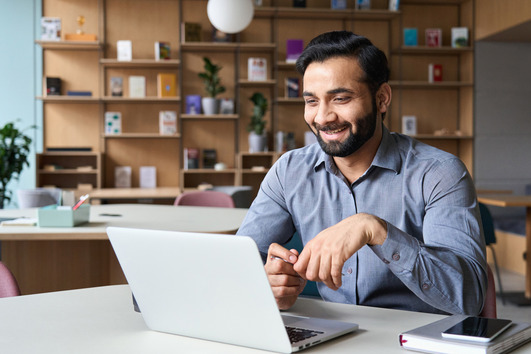 Man smiling and using laptop