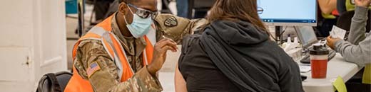 masked person giving vaccine to patient