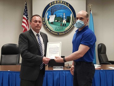 Walmart employee Terry Denicolais receives a Proclamation from Supervisor Albra for informing residents about the availability of cleaning supplies