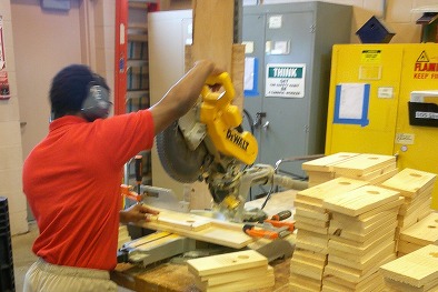 A resident of Finger Lakes Residential Center uses a saw to build bird houses