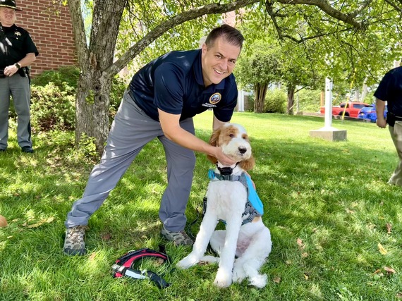 Sheriff's Office employee with a dog modeling the new life vest