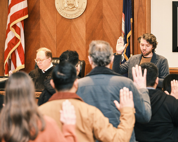 County Clerk Taylor Bruck leading new citizens in the Oath of Allegiance at the March naturalization ceremony
