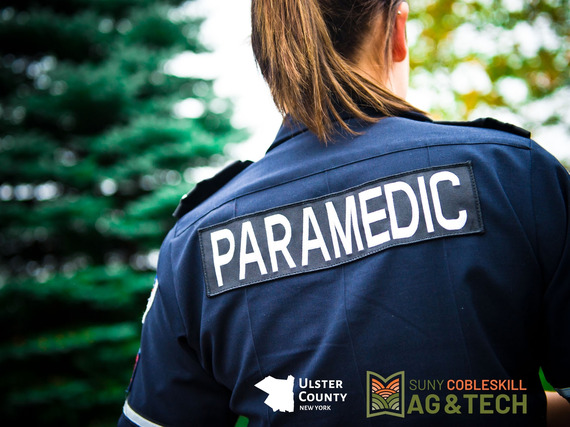 A female paramedic, with the Ulster County and SUNY Cobleskill logos added in