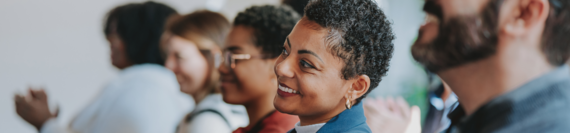 A crowd of people listening to a meeting 
