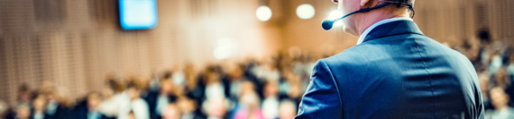 A speaker giving a presentation in front of an audience.