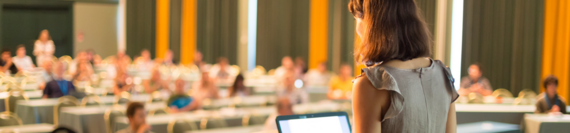 A person giving a presentation to an audience at a conference.