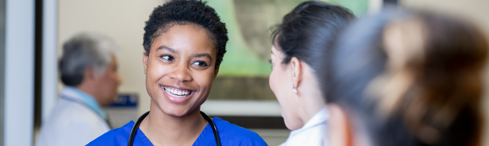 Hospital worker talking to another person and smiling