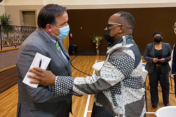 Mayor Ginther speaking with a man at the faith leaders meeting
