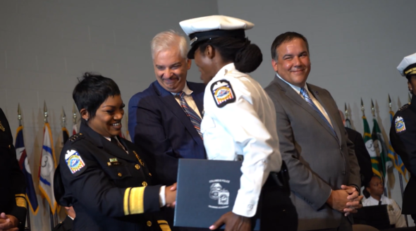 Mayor Ginther smiles at a police recruit and the 137 graduation