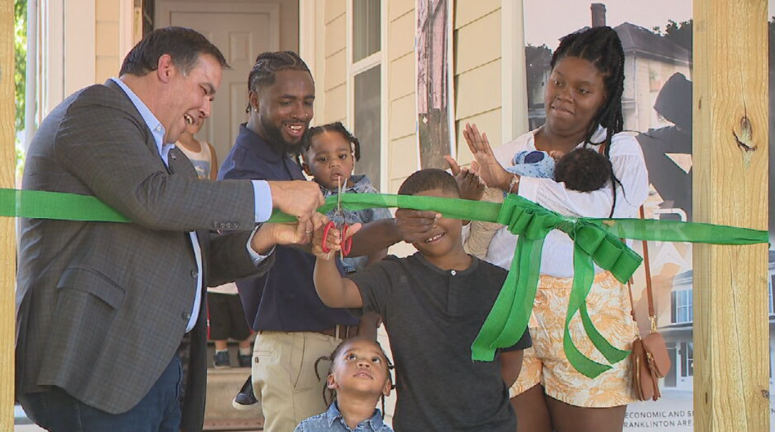 Mayor Ginther helps cut the ribbon of a new home for a family through Franklinton Rising