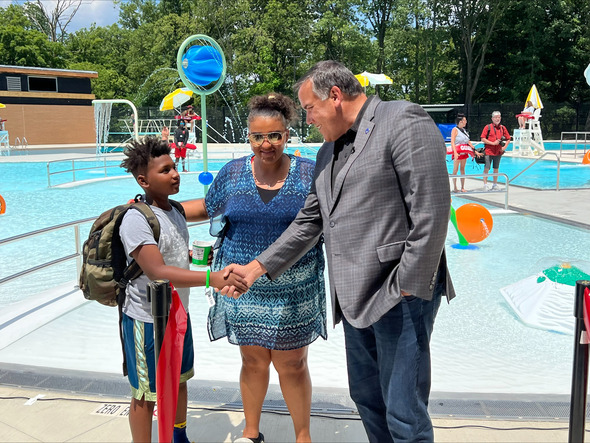 Mayor Ginther shakes the hand of a child at the ribbon cutting of Glenwood Pool
