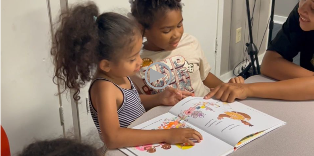 a woman reads a children's book with two young girls