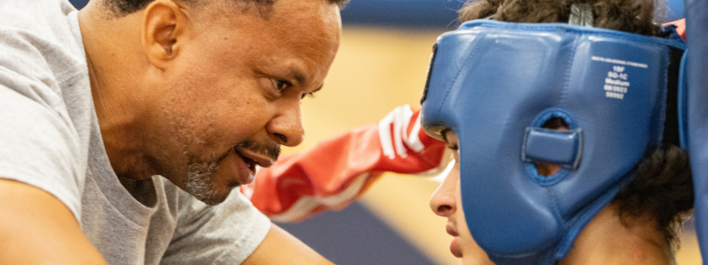 Boxing coach talking to kid