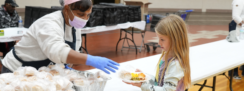 Volunteer passing out meal