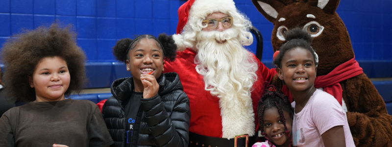 Kids posing with Santa Clause and a Reindeer 