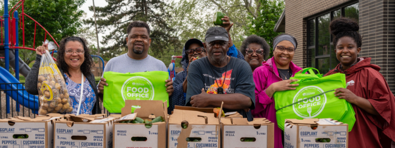Group of people holding up produce bags