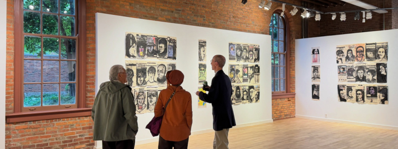 Group of people looking at art on a gallery wall 