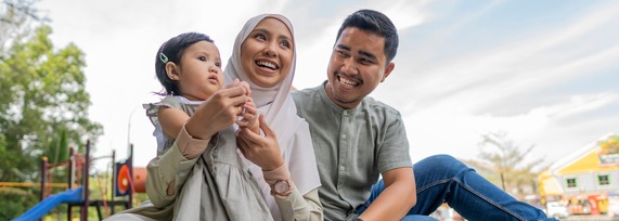Bady with Mother and Father outside playing on the grass