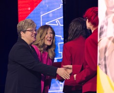 Stevie Romano shakes hands with a graduate