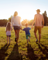 Mom, Dad, and two kids walking in the evening sun