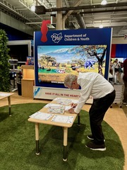 Governor DeWine colors an animal photo at the Draw Alive activity at the DCY booth.