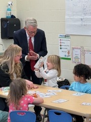 Governor DeWine claps as a preschool child shows him her letter Y practice sheet.