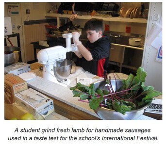 A student grind fresh lamb for handmade sausages used in a taste test for the school's International Festival.