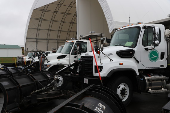 Line of snow plows in front of salt dome