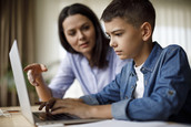 Woman and student work together on the computer.