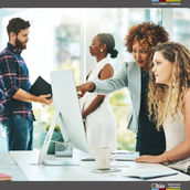 Business woman showing younger employee how to do something on the computer. 