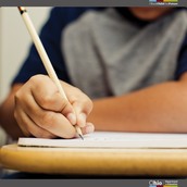 Close up image of student writing with a pencil.