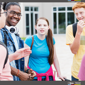 Group of high school students talking outside of a school building.