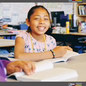 Smiling girl at a desk.