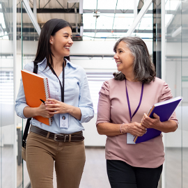 Two women walking down a hall talking